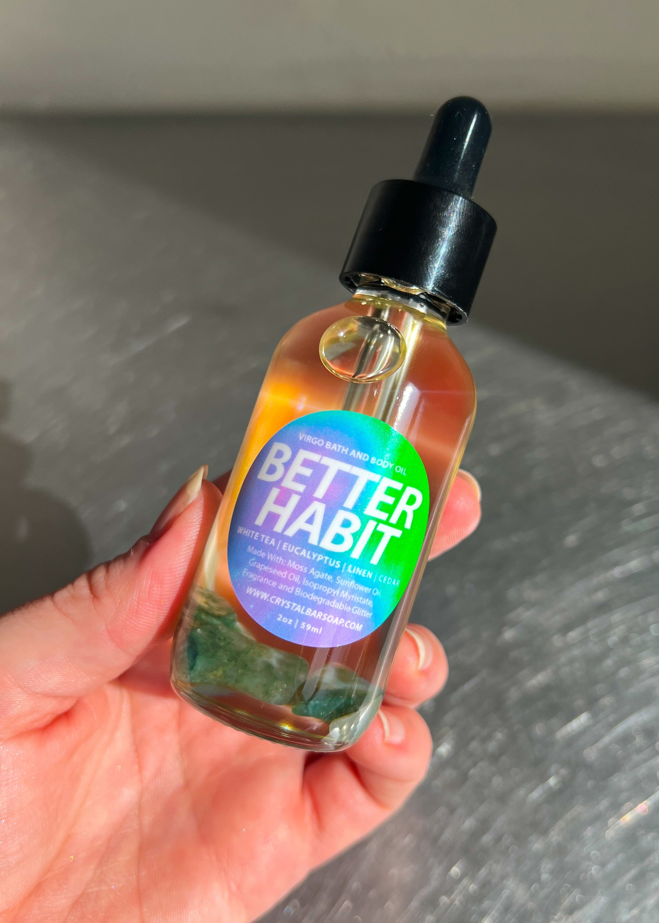 Hand holding a bottle labeled 'Better Habit' against a neutral background