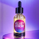 Bottle of Velvet Venom on a purple shelf with a gradient purple background
